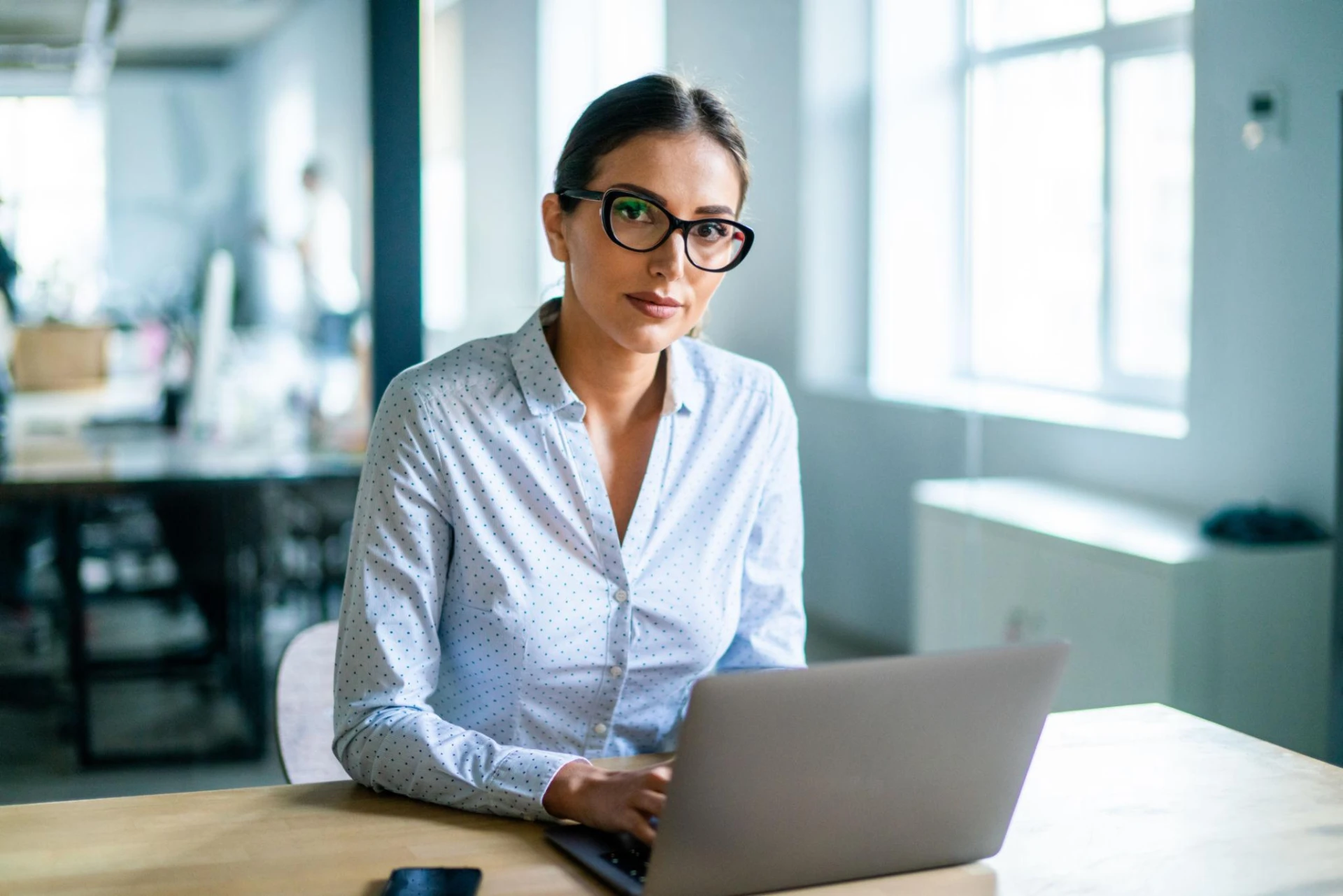 Professional working on a laptop in a bright modern office